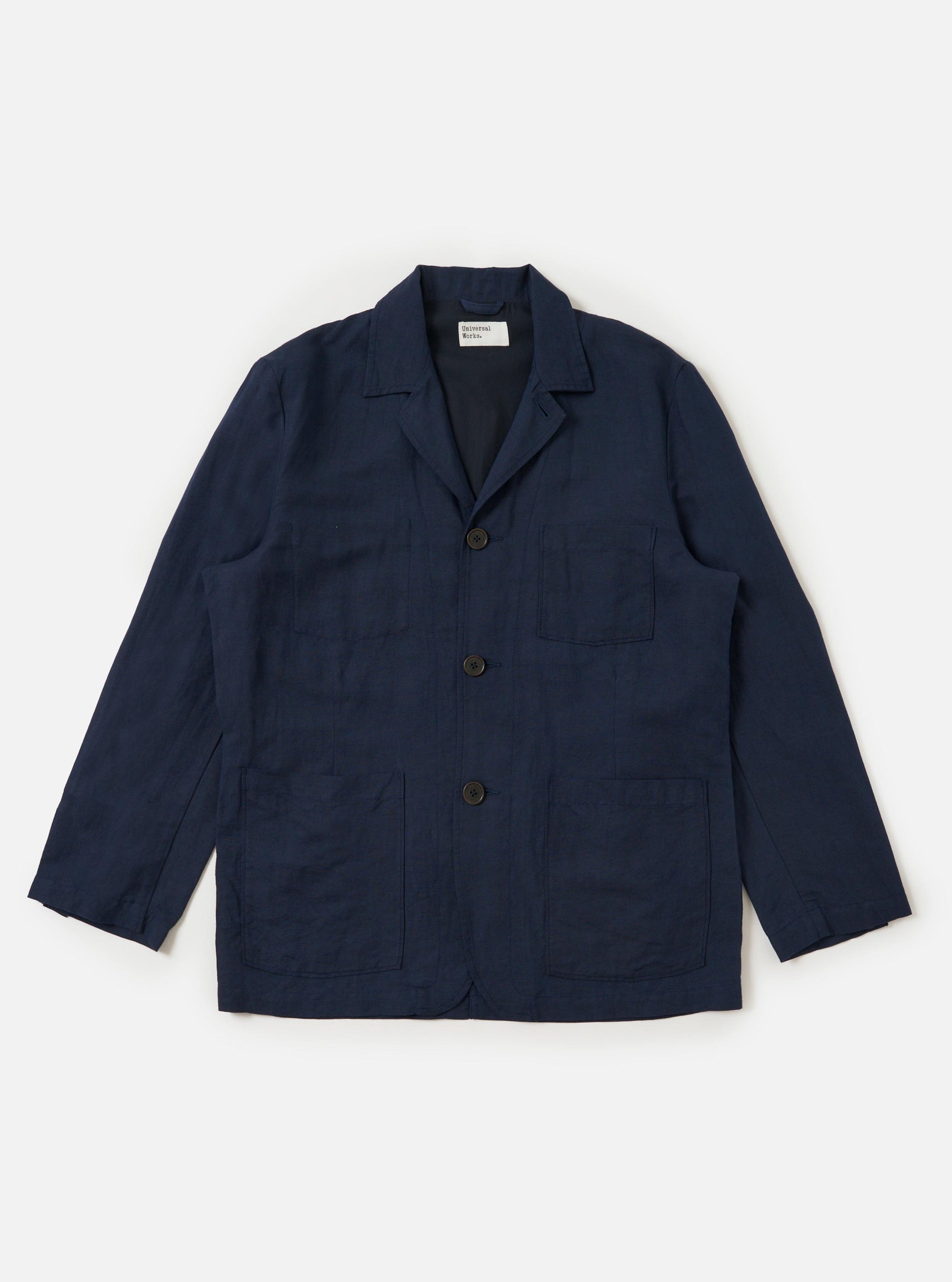 A Navy Linen Cotton Shirting Dizzy Jacket is displayed flat against a plain white background. The jacket features a classic collar, a full button-down front, and three large patch pockets on the front. The lightweight navy blue fabric has a subtle textured appearance.