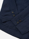 A rear view of the Navy Linen Cotton Shirting Dizzy Jacket is shown laid flat against a solid white background. The image highlights the clean construction of the back, featuring a simple straight hem and a horizontal yoke across the shoulders.