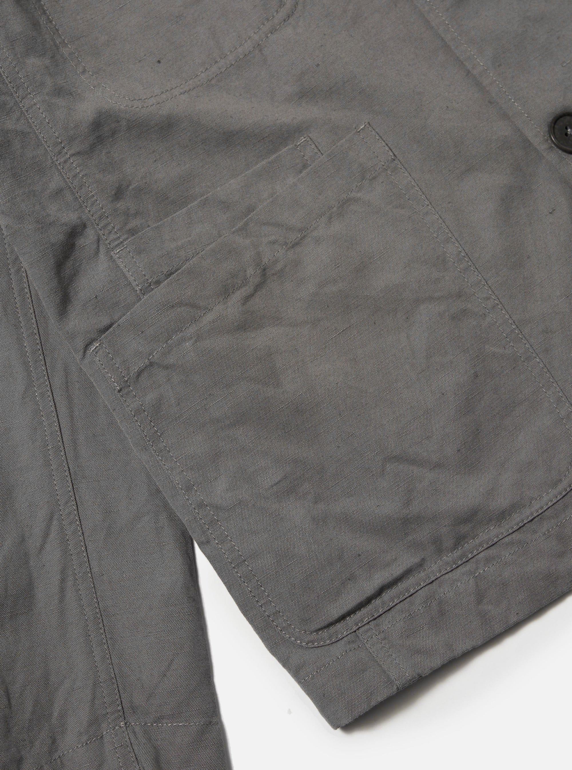 The Mid Grey Linen Slub Weave Bakers Jacket is shown from the back, displayed flat against a plain white background. The image highlights the jacket's simple, straight-cut hem and the textured, slubbed appearance of the mid-grey linen-cotton fabric.