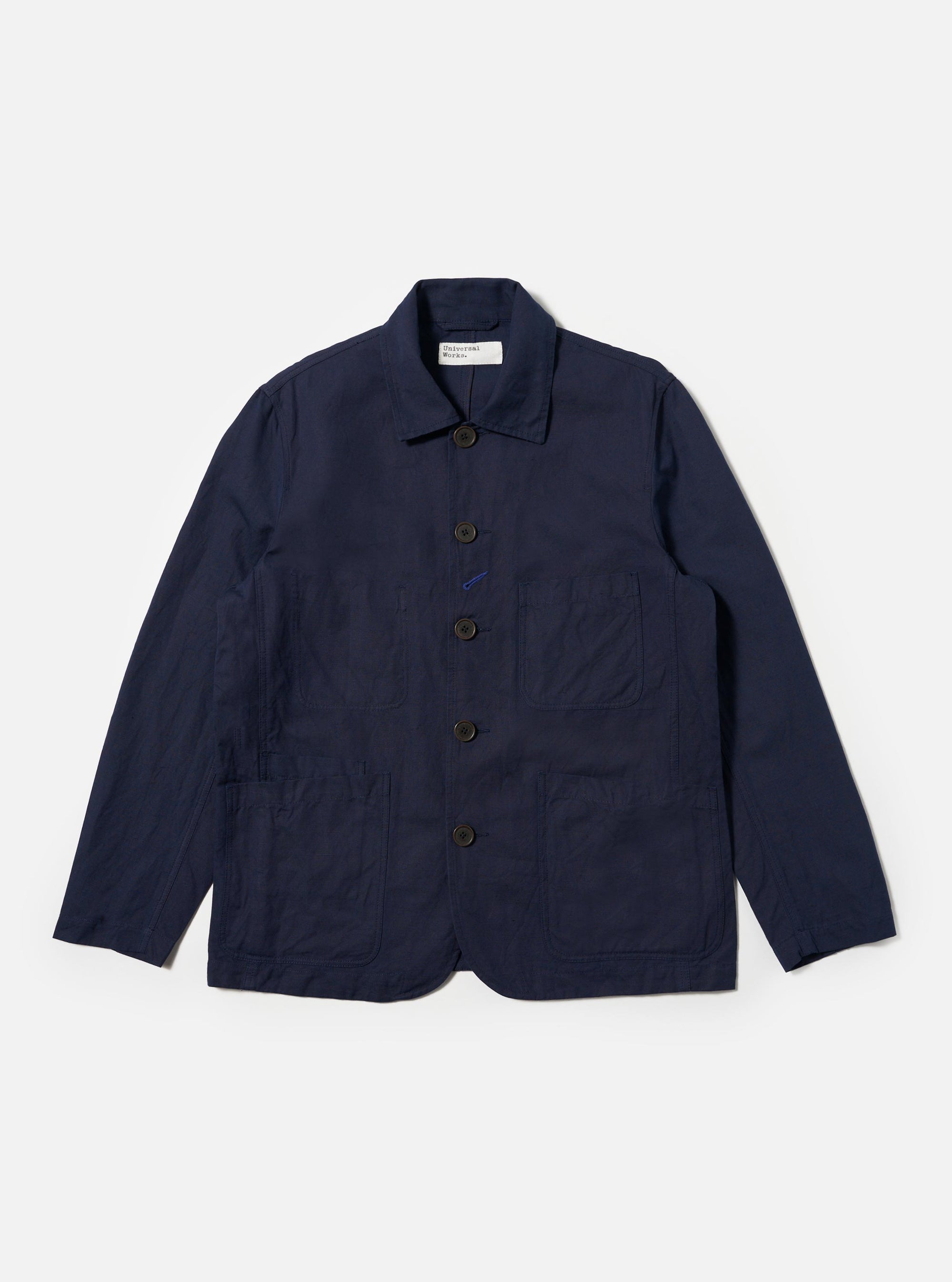 The Navy Linen Slub Weave Bakers Jacket is shown as a flat lay against a plain white background. The jacket features a five-button front closure, a notched collar, and four front patch pockets: one at the chest and three at the waist, including a smaller ticket pocket. The navy fabric has a visible textured slub weave throughout.