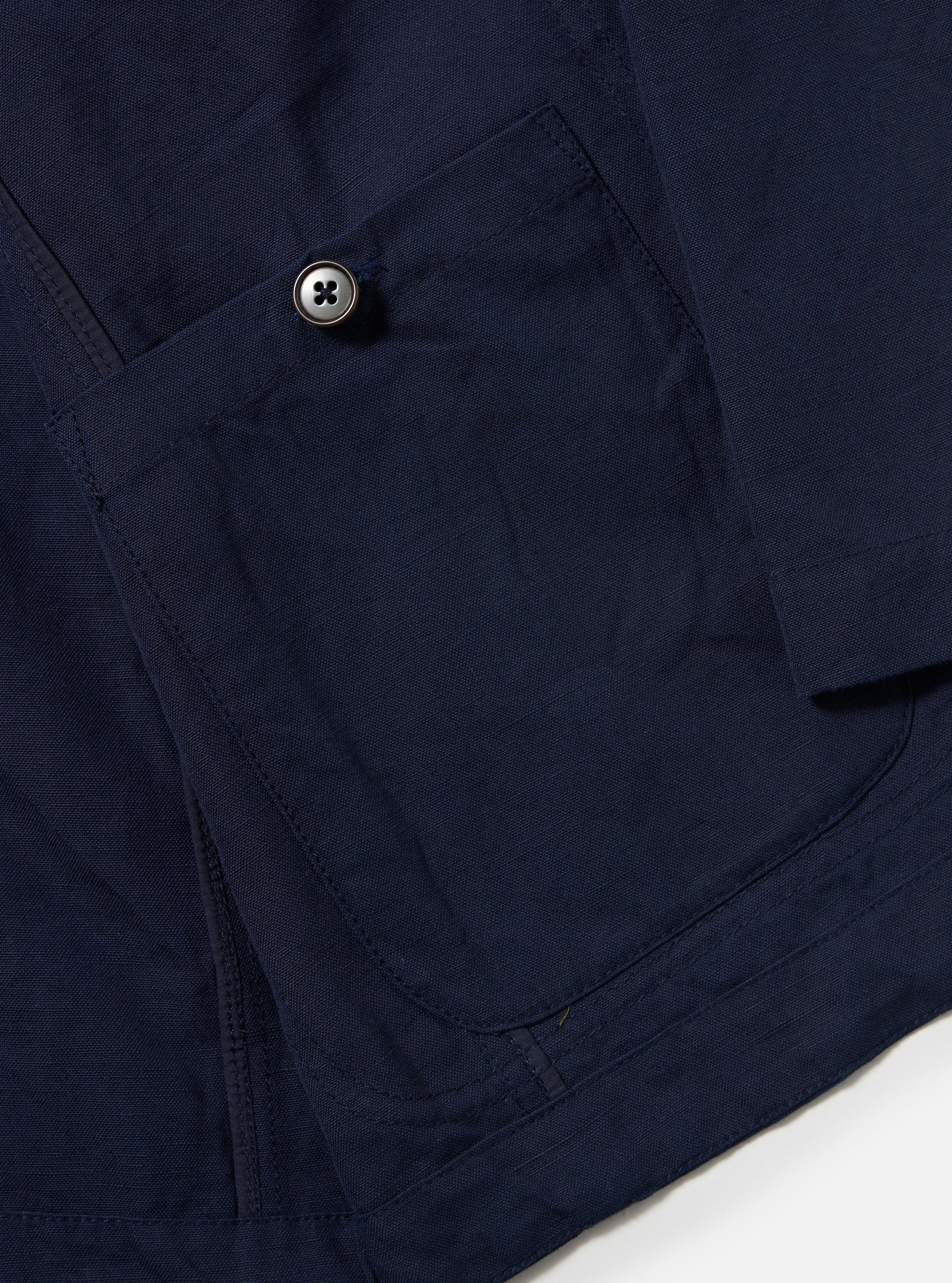 The Navy Linen Slub Weave Bakers Jacket is shown from the back, laid flat against a plain white background. The image highlights the textured, irregular slub weave of the navy blue cotton-linen fabric and the jacket's simple, straight-cut rear construction with a single-piece back panel and a clean hem.