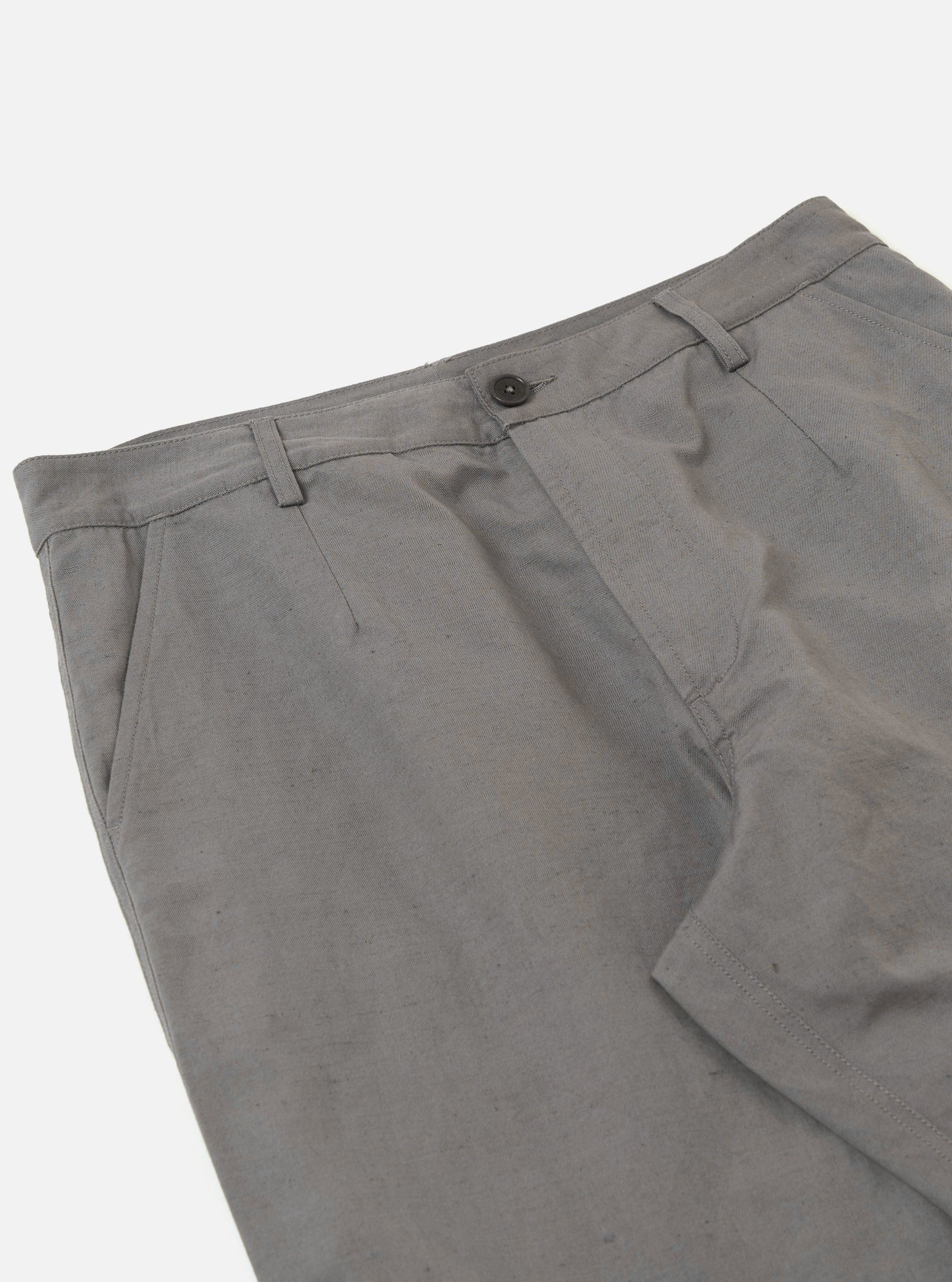 The Mid Grey Linen Slub Weave Dizzy Trouser is shown from the back as a flat lay against a plain white background. The trousers feature an elasticated waistband and two distinct rear pockets: one with a buttoned flap and one buttoned jetted pocket. The mid-grey fabric displays a visible slub texture characteristic of the linen and cotton blend.