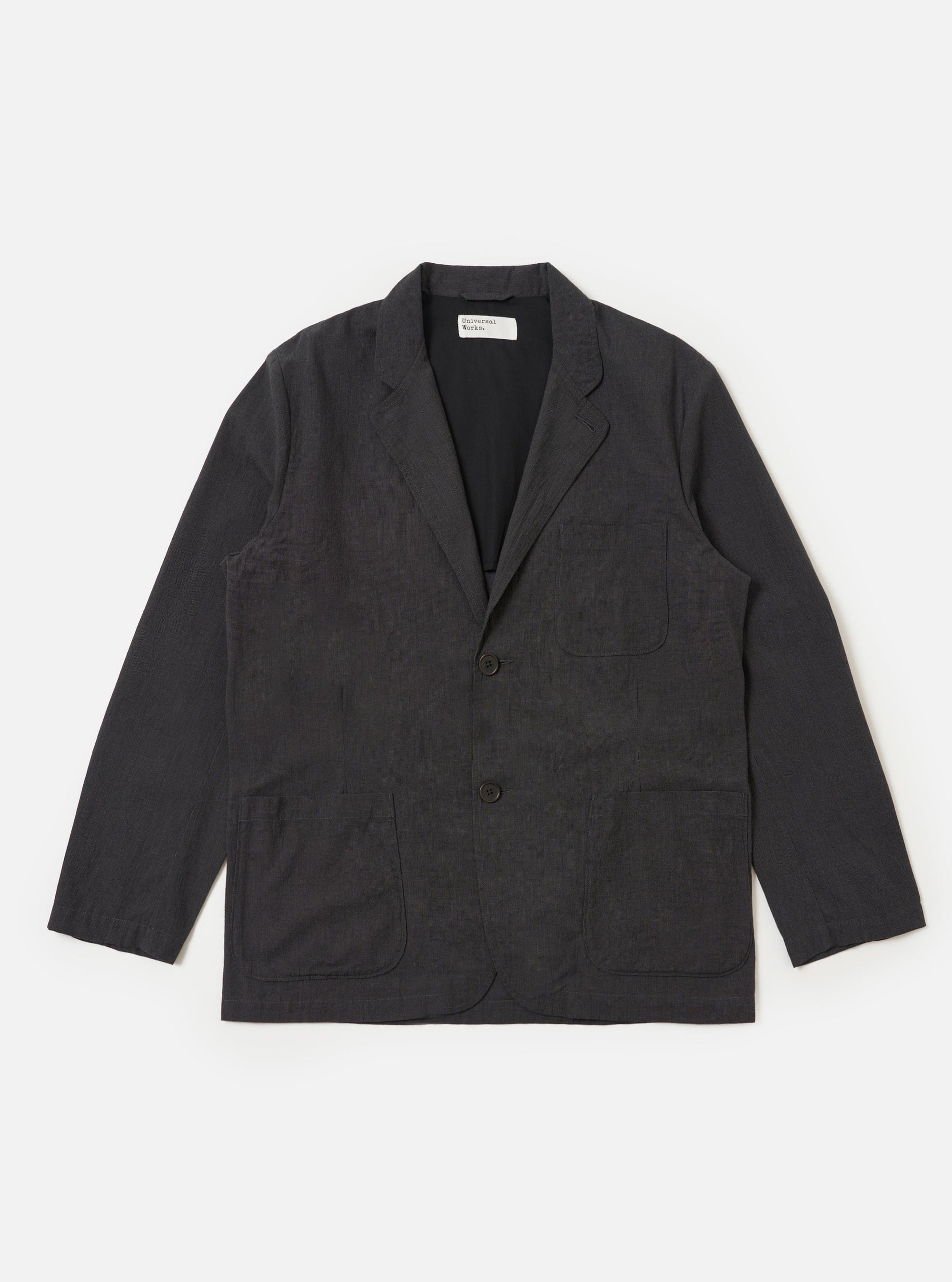 A Charcoal Seattle Cotton Two Button Jacket is displayed flat against a plain white background. The jacket features a two-button front closure, a wide notched lapel, two large lower patch pockets, and one chest patch pocket.