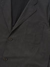 A back view of the Charcoal Seattle Cotton Two Button Jacket is displayed flat against a plain white background. The image highlights the jacket's rear construction, showing a straight hem and a subtle two-color basket weave texture in charcoal grey.