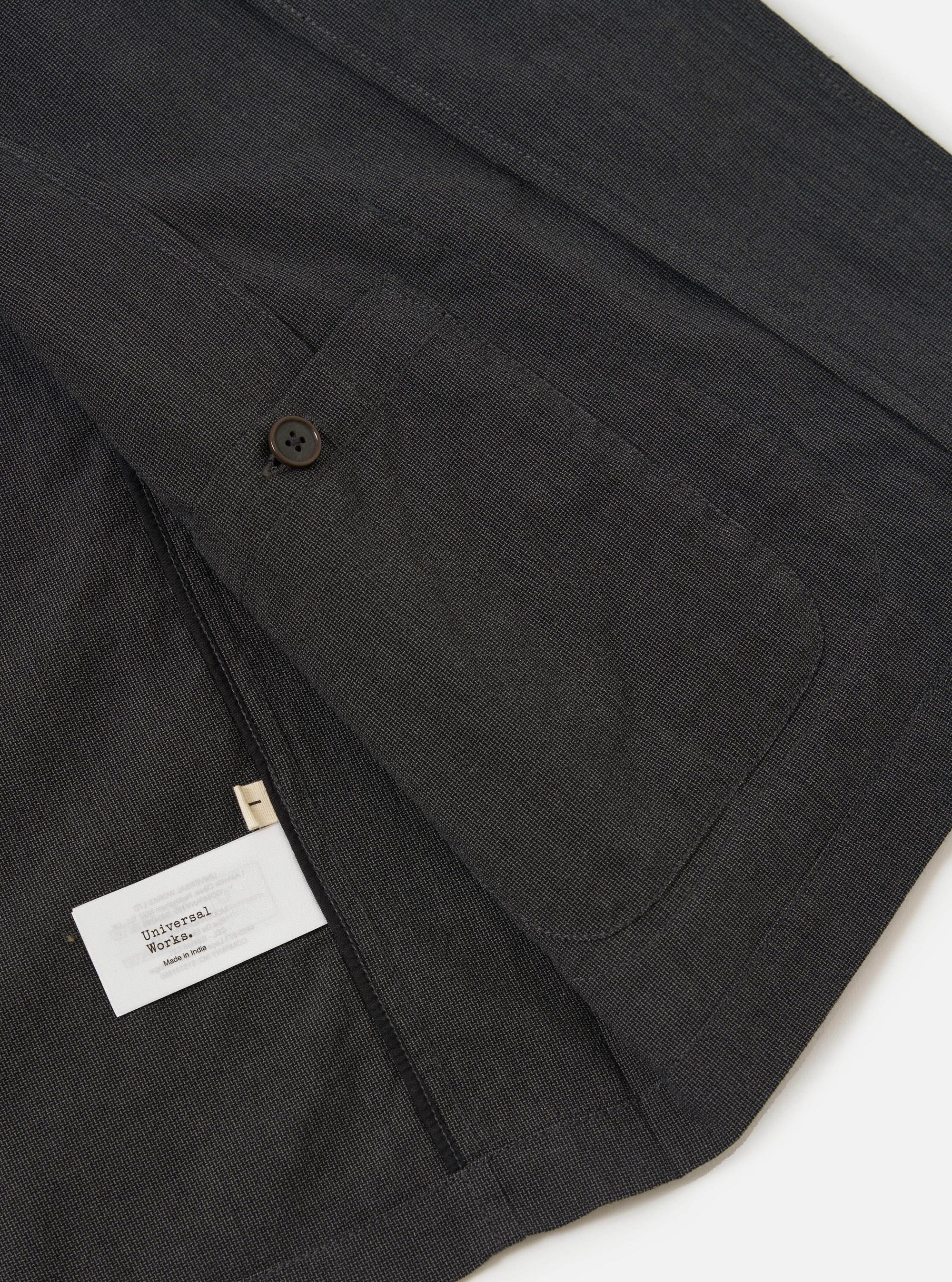 A close-up view of the Charcoal Seattle Cotton Two Button Jacket highlights the texture of the charcoal grey fabric and specific tailoring details against a plain white background.