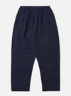 The Navy Linen Slub Weave Oxford Pant is shown laid flat against a plain white background. The deep navy trousers feature a loose, wide-leg silhouette, an elasticated waistband with a prominent external drawstring, and side slip pockets. The image highlights the irregular slubbed texture of the linen-cotton fabric.