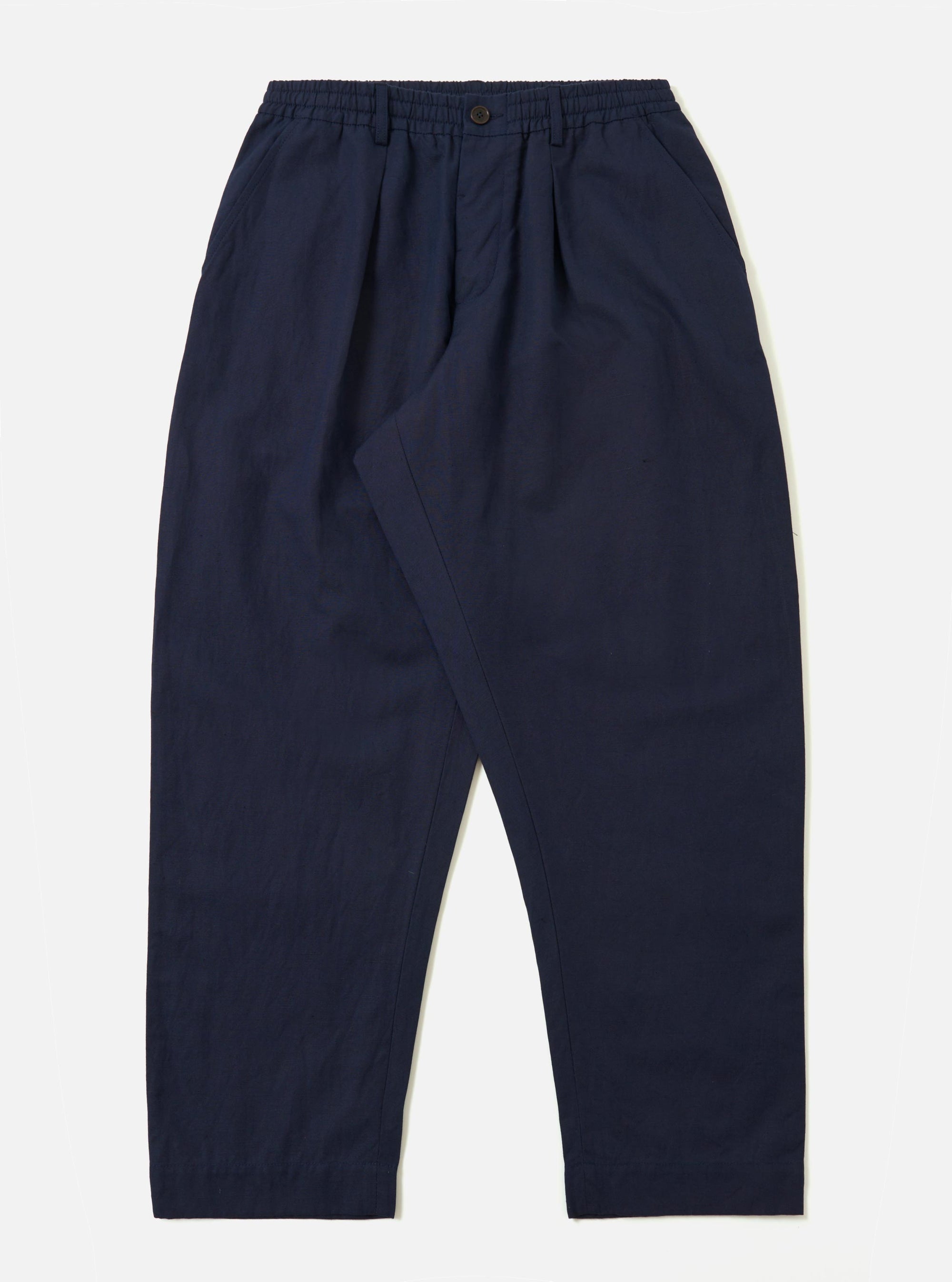 The Navy Linen Slub Weave Oxford Pant is shown laid flat against a plain white background. The deep navy trousers feature a loose, wide-leg silhouette, an elasticated waistband with a prominent external drawstring, and side slip pockets. The image highlights the irregular slubbed texture of the linen-cotton fabric.