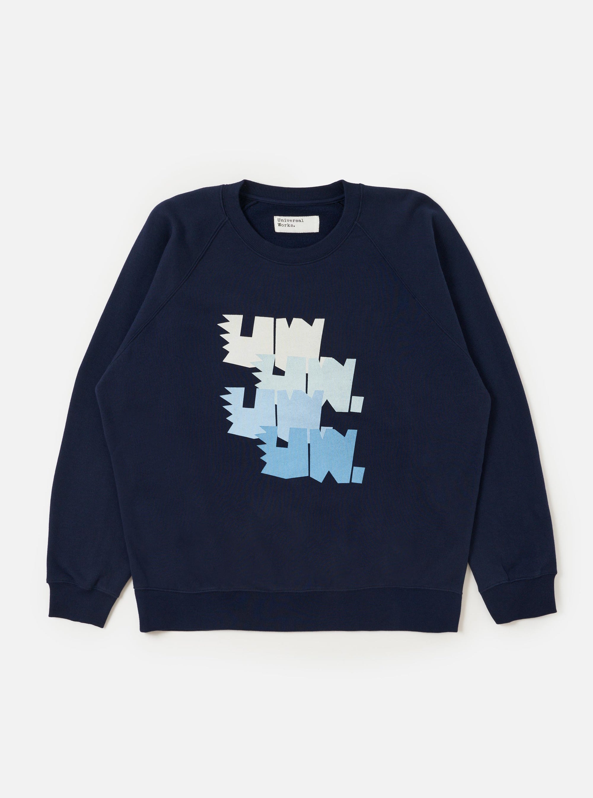 A navy blue Brush Back Sweat FM Raglan Sweatshirt is shown laid flat against a plain white background. The garment features raglan sleeves, a classic crew neckline, and ribbed texture on the collar, cuffs, and hem.
