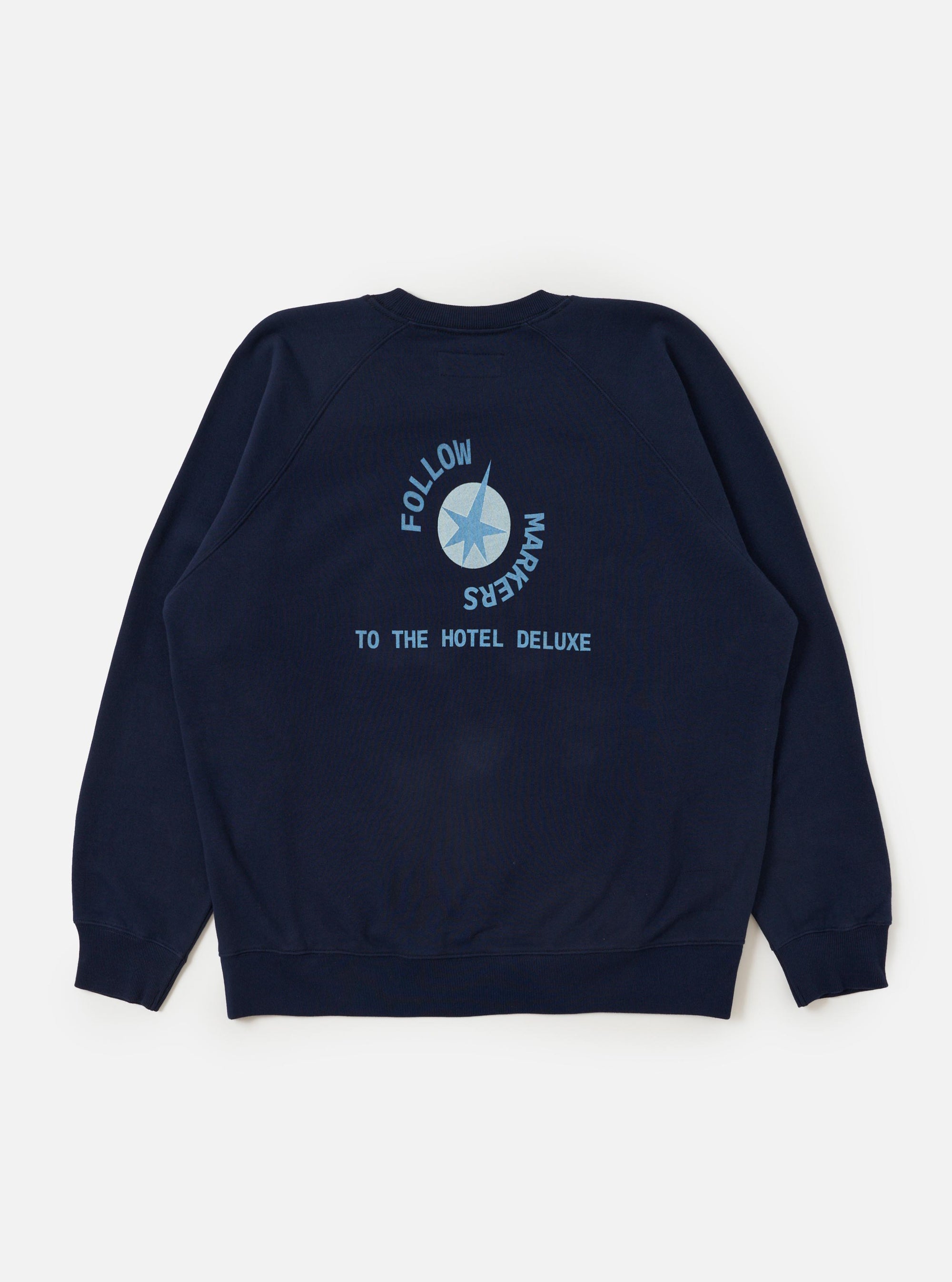 The Navy Brush Back Sweat FM Raglan Sweatshirt is shown from the back, laid flat against a plain white background. The image highlights the raglan sleeve construction with diagonal seams extending to the neckline, along with a ribbed collar, cuffs, and hem.