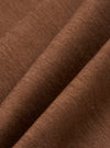 A close-up fabric swatch of the brown Meco denim from the Hi Water Trouser shows a detailed diagonal twill weave. The image captures the texture and earthy brown color of the material.