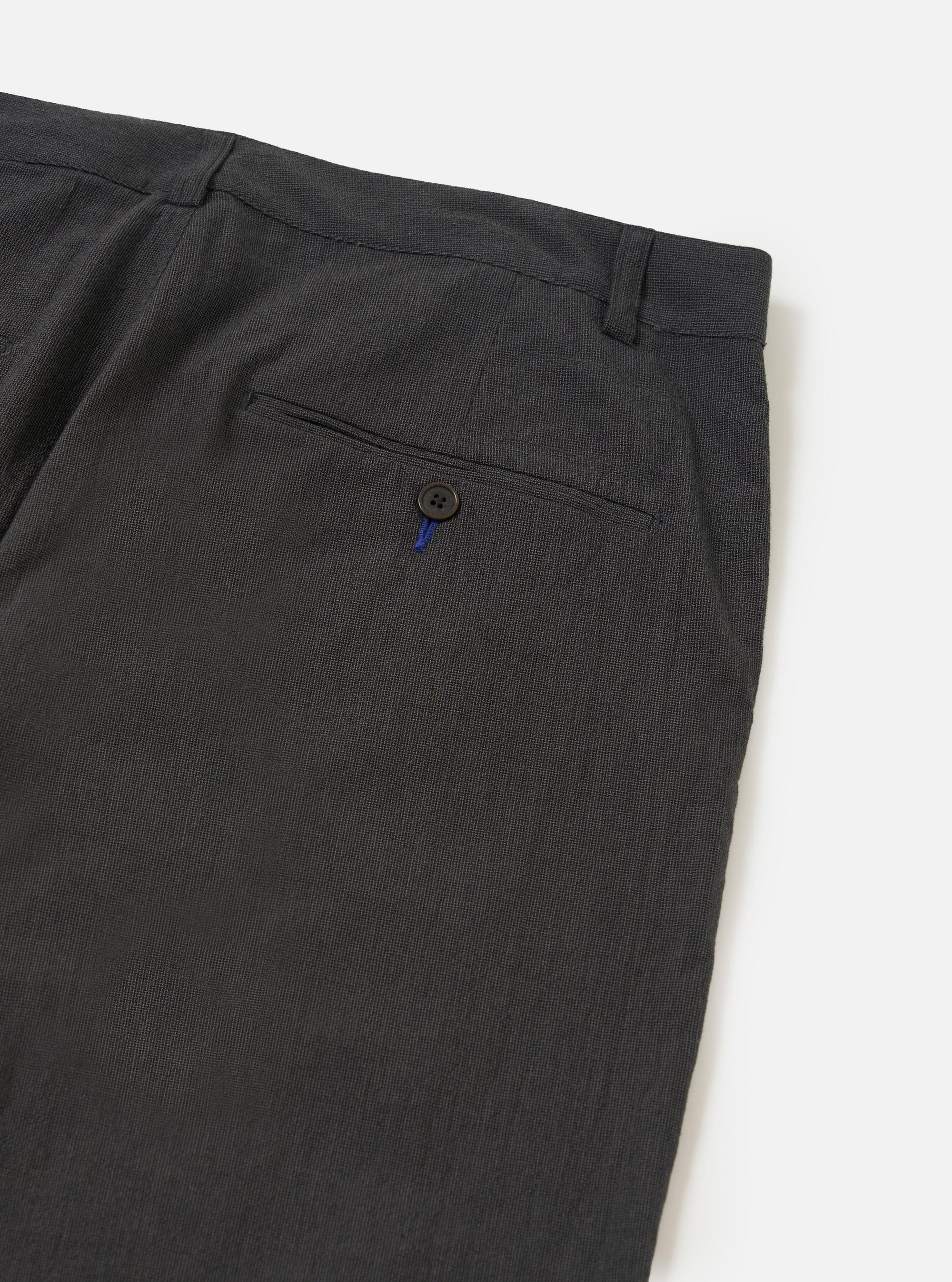 A close-up view of the back of a pair of Charcoal Seattle Cotton Military Chinos, focusing on the waistband and a single rear buttoned flap pocket. The charcoal grey cotton fabric is shown against a plain white background.