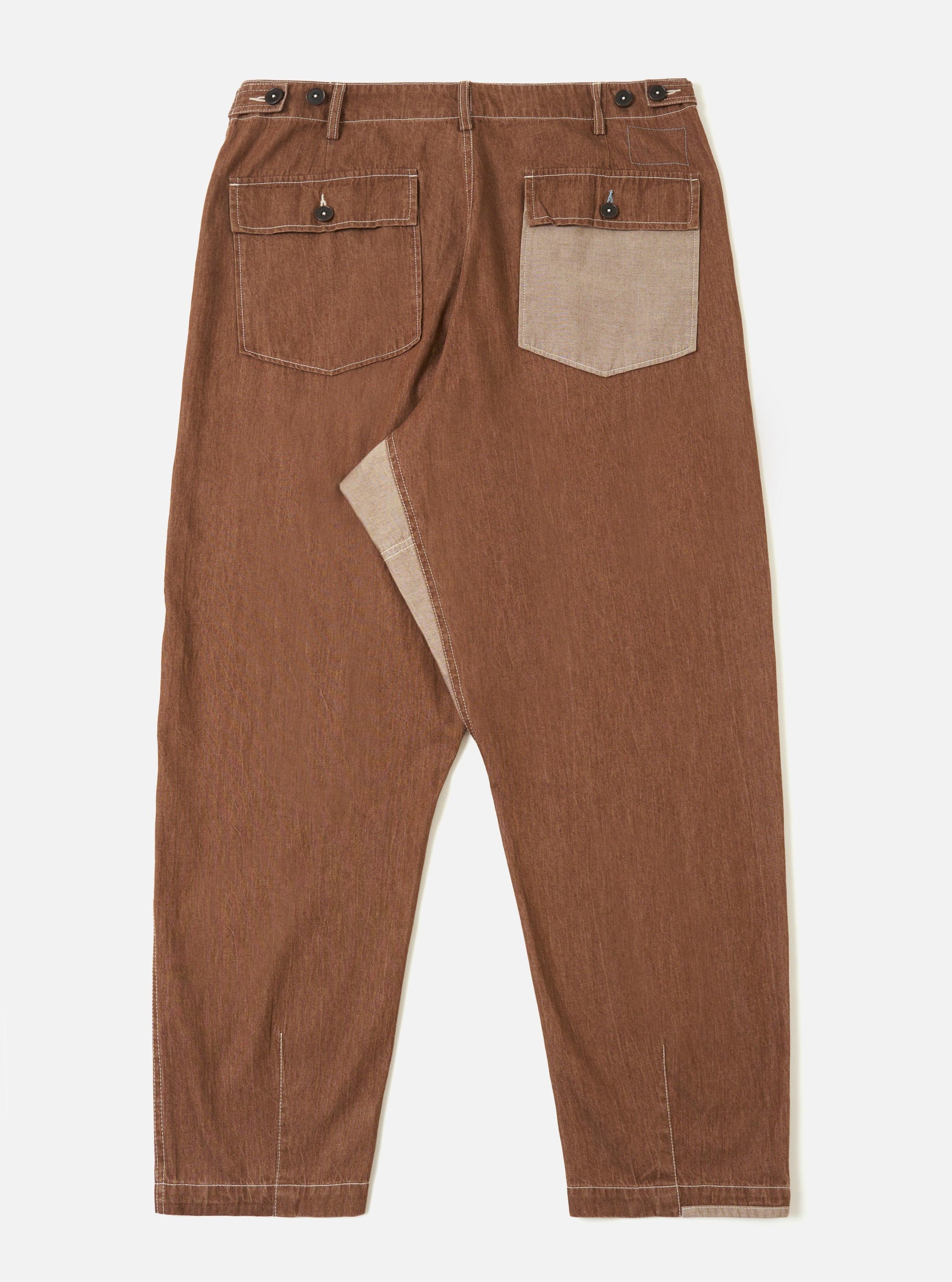 A pair of brown Meco denim patched fatigue pants is shown from the back, laid flat against a plain white background. The image highlights the two large rear patch pockets and the straight-leg cut of the trousers.