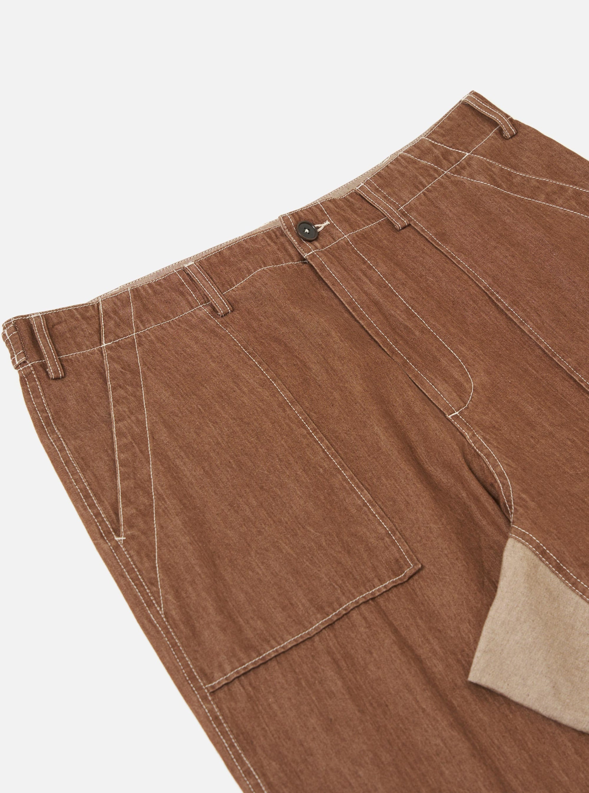 A pair of brown meco denim patched fatigue pants is displayed flat against a plain white background. The trousers feature a straight leg, large patch pockets, and tonal reinforcement patches.