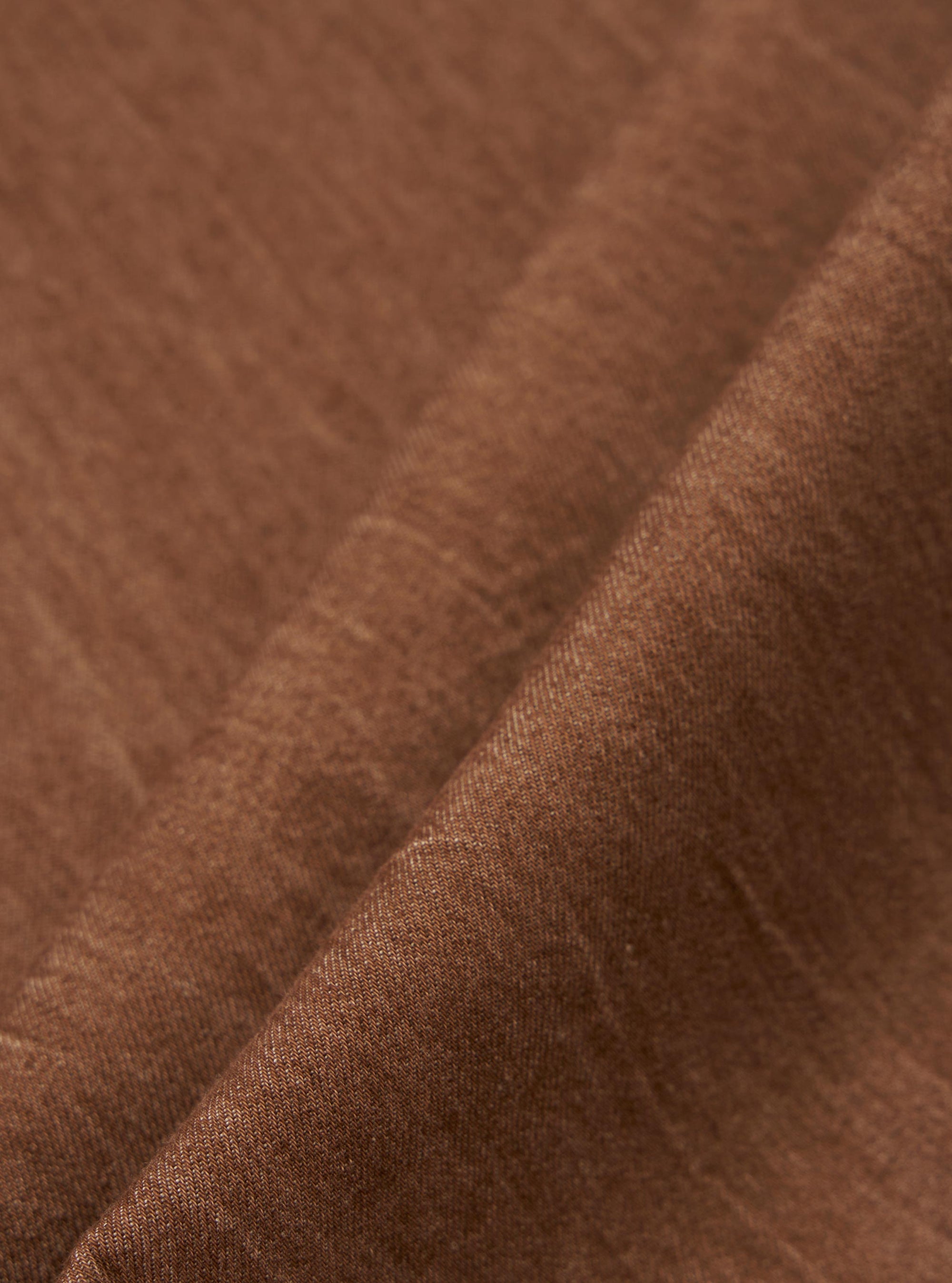 A close-up swatch of the brown Meco denim fabric used for the patched fatigue pant. The image displays the texture and color of the material.