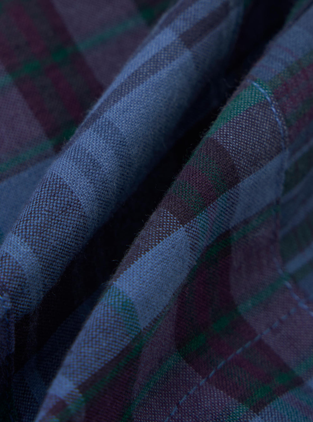 A close-up fabric swatch of the Navy Madras Patchwork Vacation Short shows a textured patchwork design with various blue and navy checkered patterns.