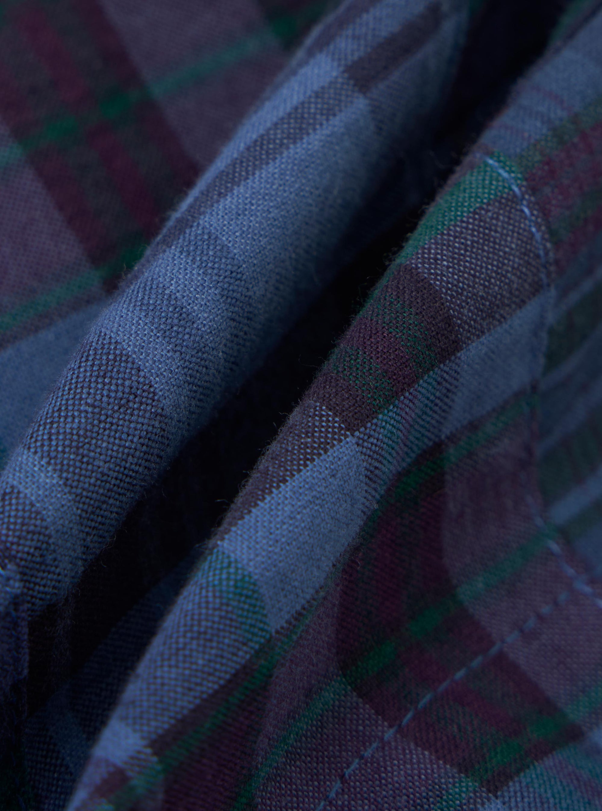 A close-up fabric swatch of the Navy Madras Patchwork Vacation Short shows a textured patchwork design with various blue and navy checkered patterns.