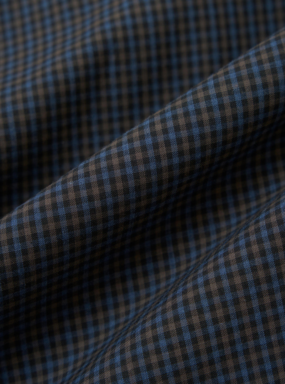 A close-up, square fabric swatch of the Navy Check Plaid Summer Overshirt highlights a detailed plaid pattern. The design features intersecting navy blue and white lines creating a textured, multi-tonal check effect.