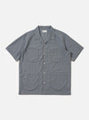 A Pale Blue Check Plaid Summer Overshirt is shown laid flat against a solid white background. The garment features a light blue and white plaid pattern, a classic pointed collar, a full button-down front, and two large utility chest pockets with buttoned flaps.