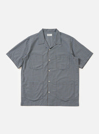 A Pale Blue Check Plaid Summer Overshirt is shown laid flat against a solid white background. The garment features a light blue and white plaid pattern, a classic pointed collar, a full button-down front, and two large utility chest pockets with buttoned flaps.