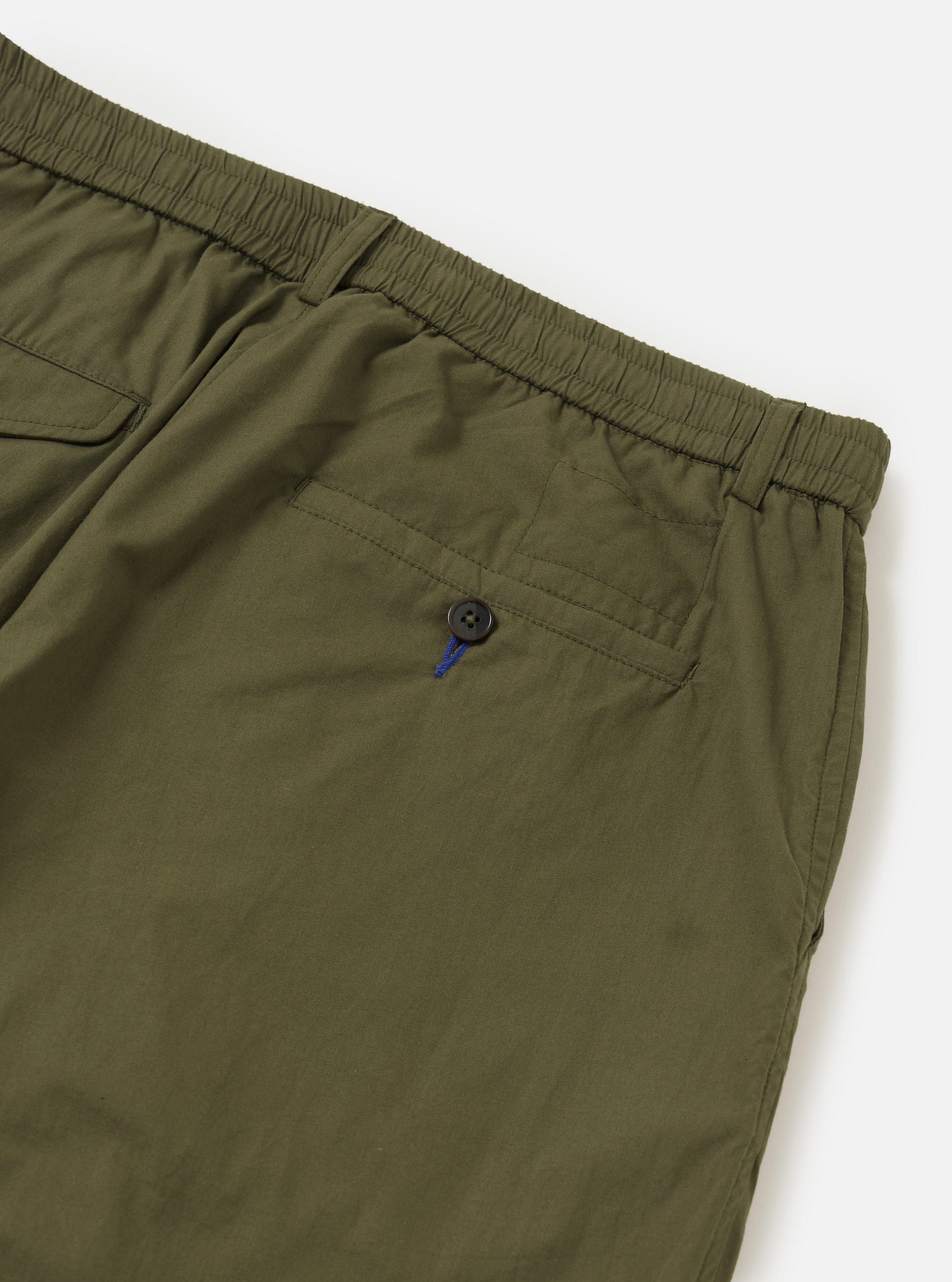 The Olive Broadcloth Oxford Pant is shown from a rear perspective, laid flat against a solid white background. The image highlights the back of the waistband, which includes a central hanging loop and two large patch pockets with buttoned flap closures.