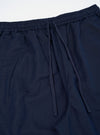 A pair of Navy Linen Cotton Shirting Parachute Pants is shown from the rear, laid flat against a plain white background. The image highlights the two large rear accordion patch pockets with buttoned flaps and the drawstring hem at the ankles.