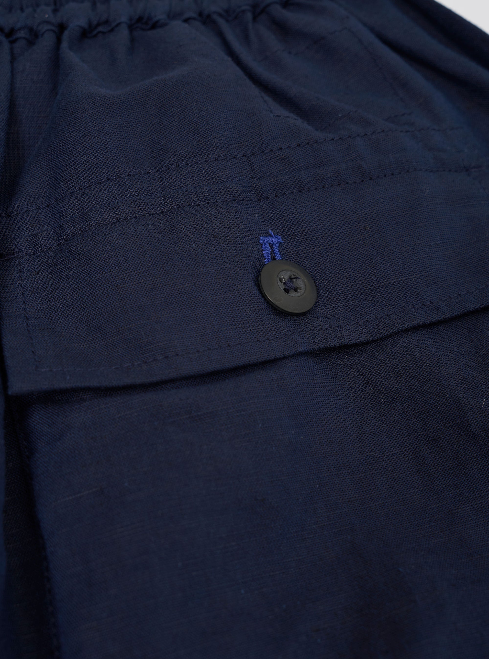 The Navy Linen Cotton Shirting Parachute Pant is shown from the back, laid flat against a plain white background. The image highlights the two large rear patch pockets, the elasticated waistband, and the relaxed, straight-leg silhouette of the dark navy trousers.