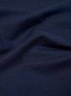 A close-up fabric swatch of the Navy Linen Cotton Shirting Parachute Pant shows a detailed view of the navy blue material. The image highlights the textured weave and the blend of linen and cotton fibers.
