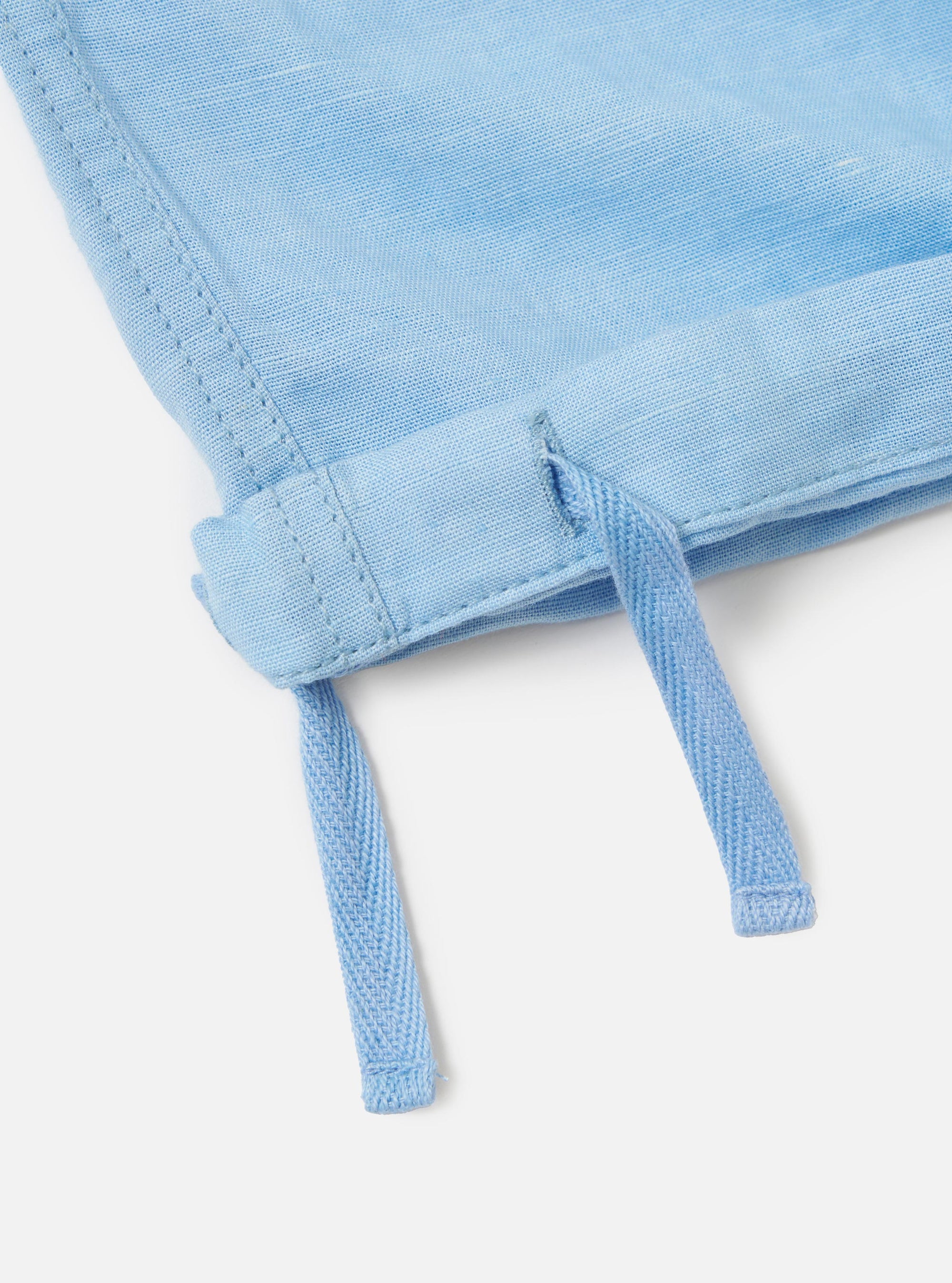 A pair of Pale Blue Linen Cotton Shirting Parachute Pants is displayed from a rear view, focusing on the waistband and the lightweight, textured fabric. The garment is laid flat against a plain white background.