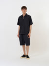 A pair of Navy Broadcloth Vacation Shorts is displayed flat against a plain white background. The shorts feature a solid navy blue color, an elasticated waistband with a visible white drawstring, and side slip pockets.
