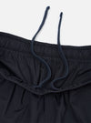 A pair of Navy Broadcloth Vacation Shorts is shown from a close-up perspective, highlighting the texture of the navy blue cotton fabric and the stitching details of a pocket. The garment is laid flat against a plain white background.