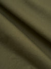 A close-up fabric swatch of the Olive Broadcloth Vacation Short displays the smooth, tight weave of the olive green cotton broadcloth. The image focuses on the uniform color and texture of the material.