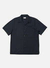 A Navy Broadcloth Camp Shirt is displayed laid flat against a plain white background. The shirt features a dark navy cotton broadcloth fabric, an open camp collar, a full button-down front, and a single large patch pocket on the left chest.