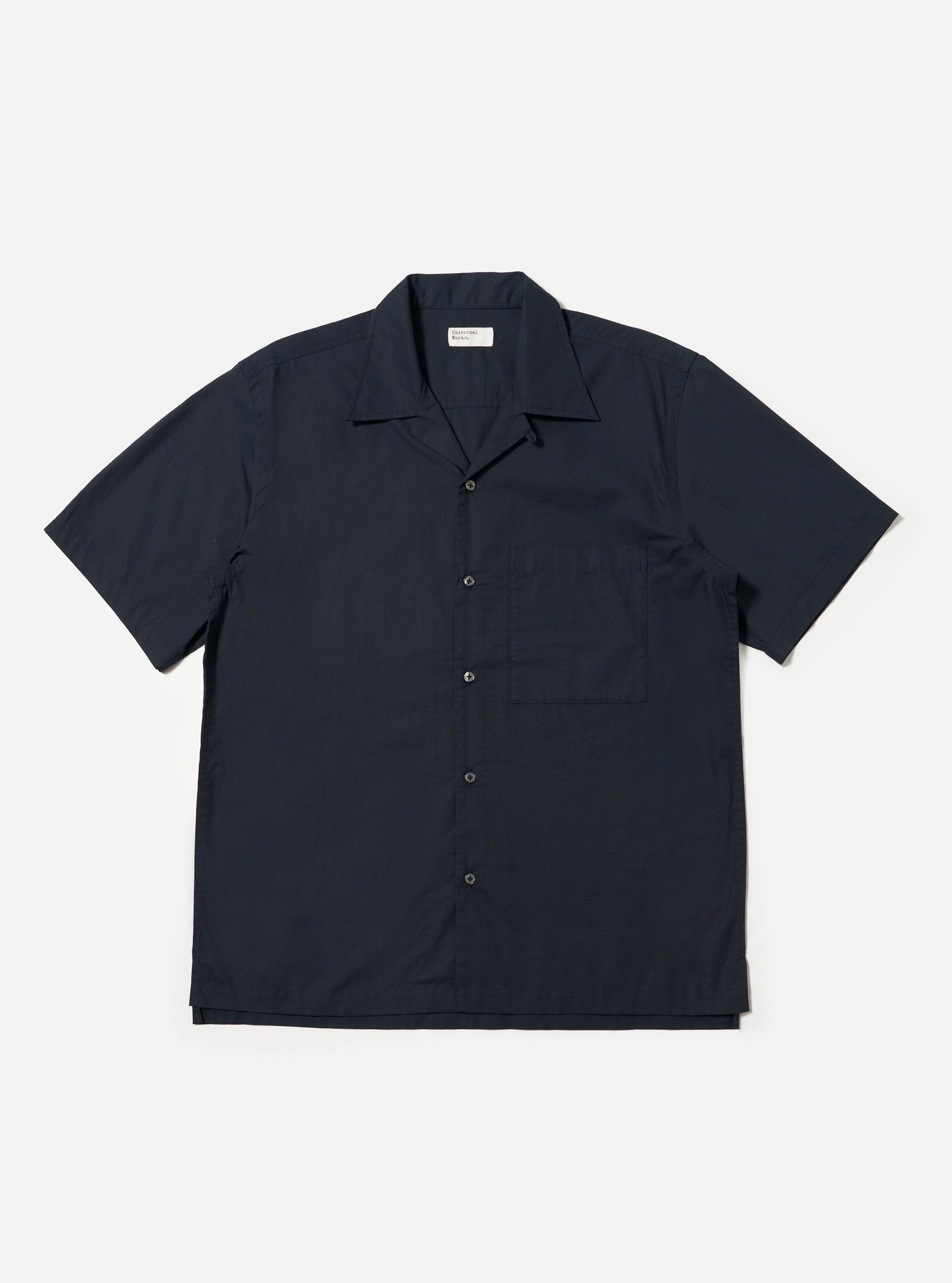 A Navy Broadcloth Camp Shirt is displayed laid flat against a plain white background. The shirt features a dark navy cotton broadcloth fabric, an open camp collar, a full button-down front, and a single large patch pocket on the left chest.
