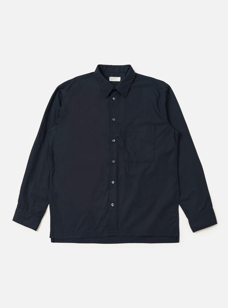 The Navy Broadcloth Lucky Shirt is shown laid flat against a solid white background. The garment is a short-sleeved button-up shirt featuring a classic pointed collar, a full button-down front, and two large patch pockets on the chest. The navy blue broadcloth fabric appears smooth and uniform in color.