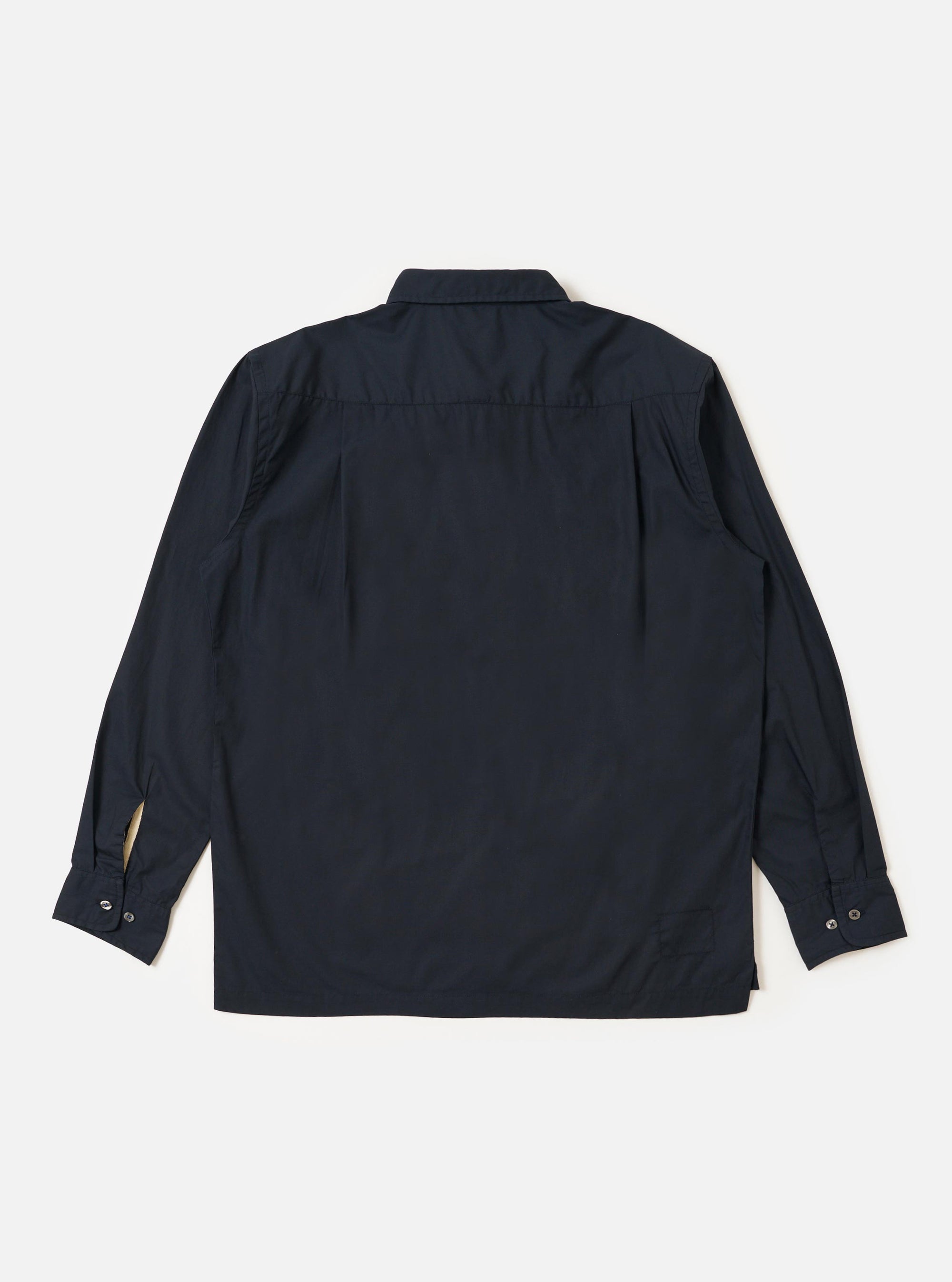 The Navy Broadcloth Lucky Shirt is shown from the back, displayed flat against a plain white background. The image highlights the shirt's straight hem, back yoke, and a central box pleat designed for a relaxed fit. The long sleeves are visible, and