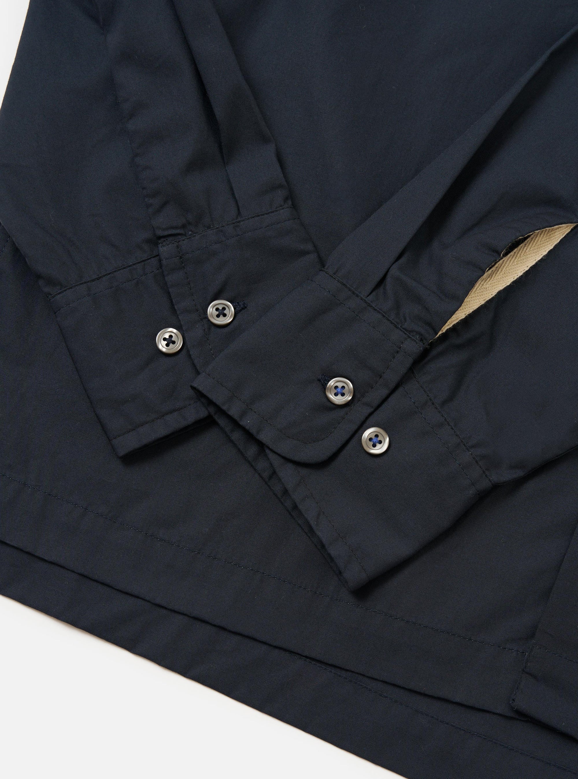 The Navy Broadcloth Lucky Shirt is shown from the back, laid flat against a solid white background. The image highlights the construction of the back yoke and a central box pleat designed for a relaxed fit.
