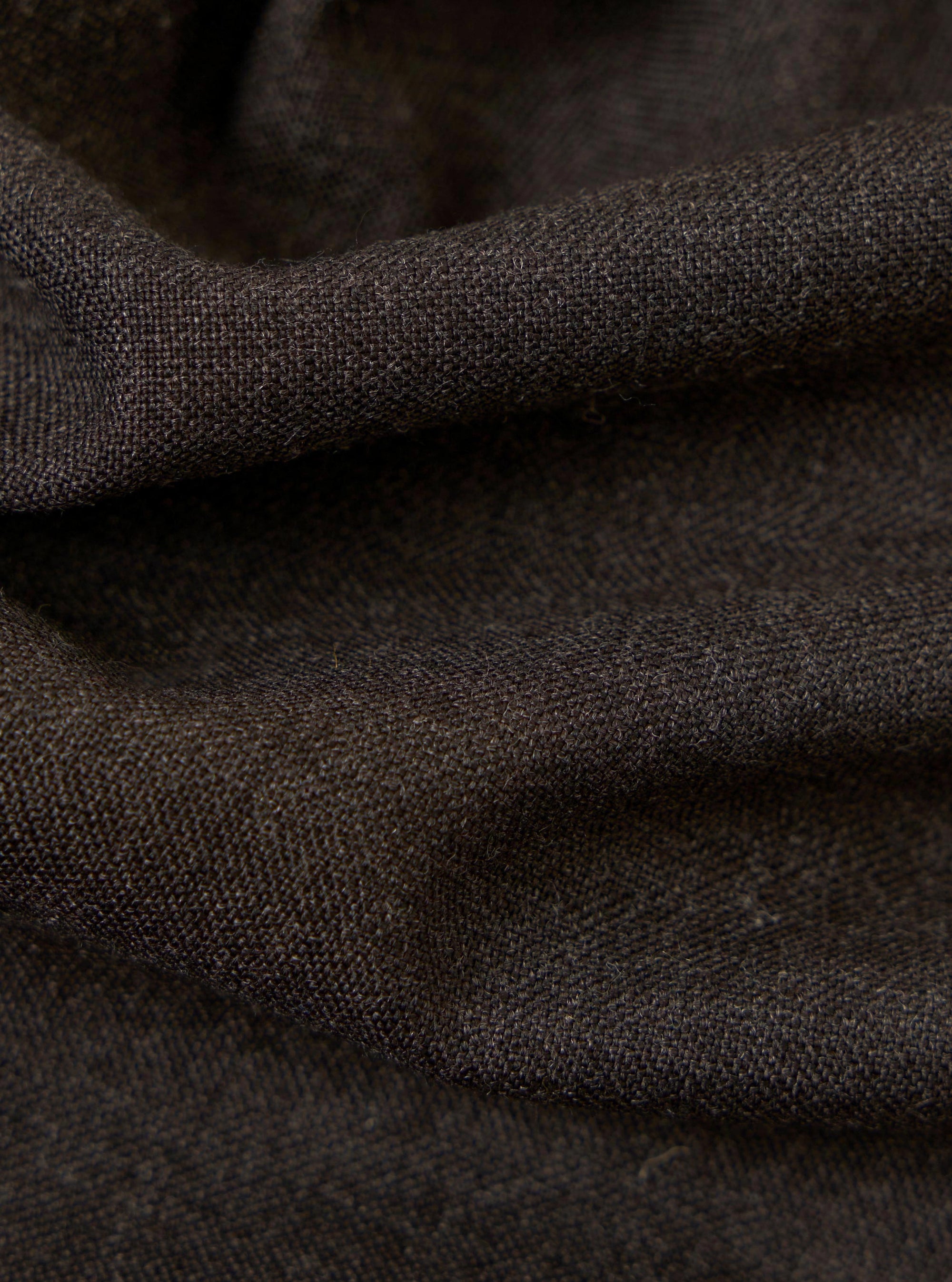 A close-up, square fabric swatch of the Brown Marl Tropical Suiting Vacation Short highlights the textured, woven appearance of the material. The fabric features a mix of brown and grey tones, creating a marled effect. No models, mannequins, or background elements are present in this detail-focused image.