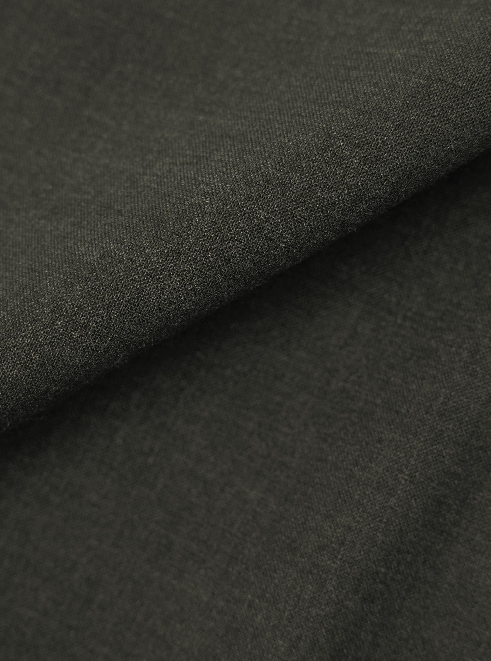 A close-up, square fabric swatch displays the detailed texture and color of the Olive Marl Tropical Suiting Vacation Short. The fabric features a fine, woven marl pattern in shades of olive green.