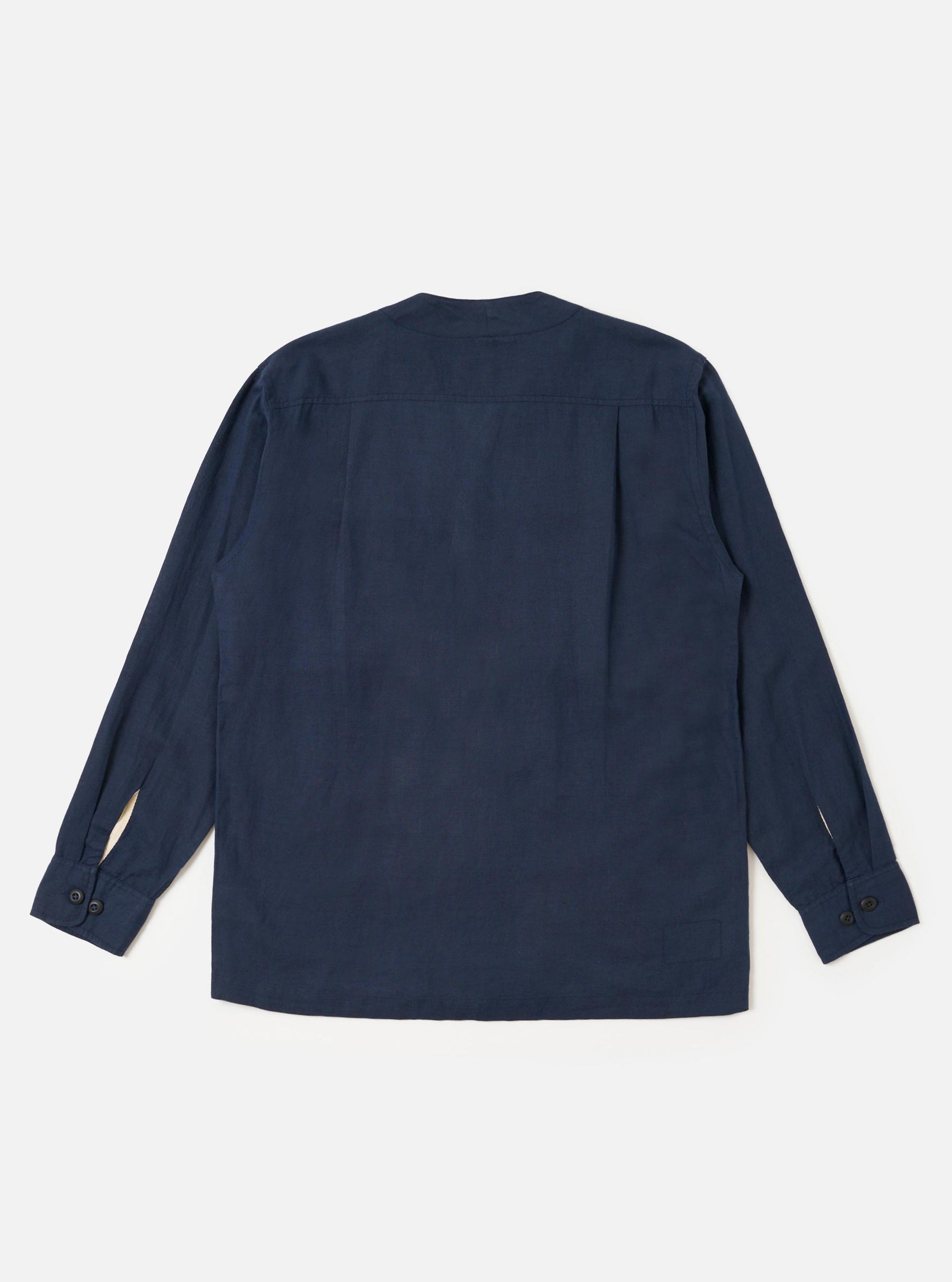 The Navy Linen Cotton Shirting Parachute Shirt is shown from the back, laid flat against a plain white background. The image highlights the horizontal back yoke with two small pleats and the adjustable buttoned cuffs on the long sleeves. The shirt features a straight hem and a collarless V-neckline.