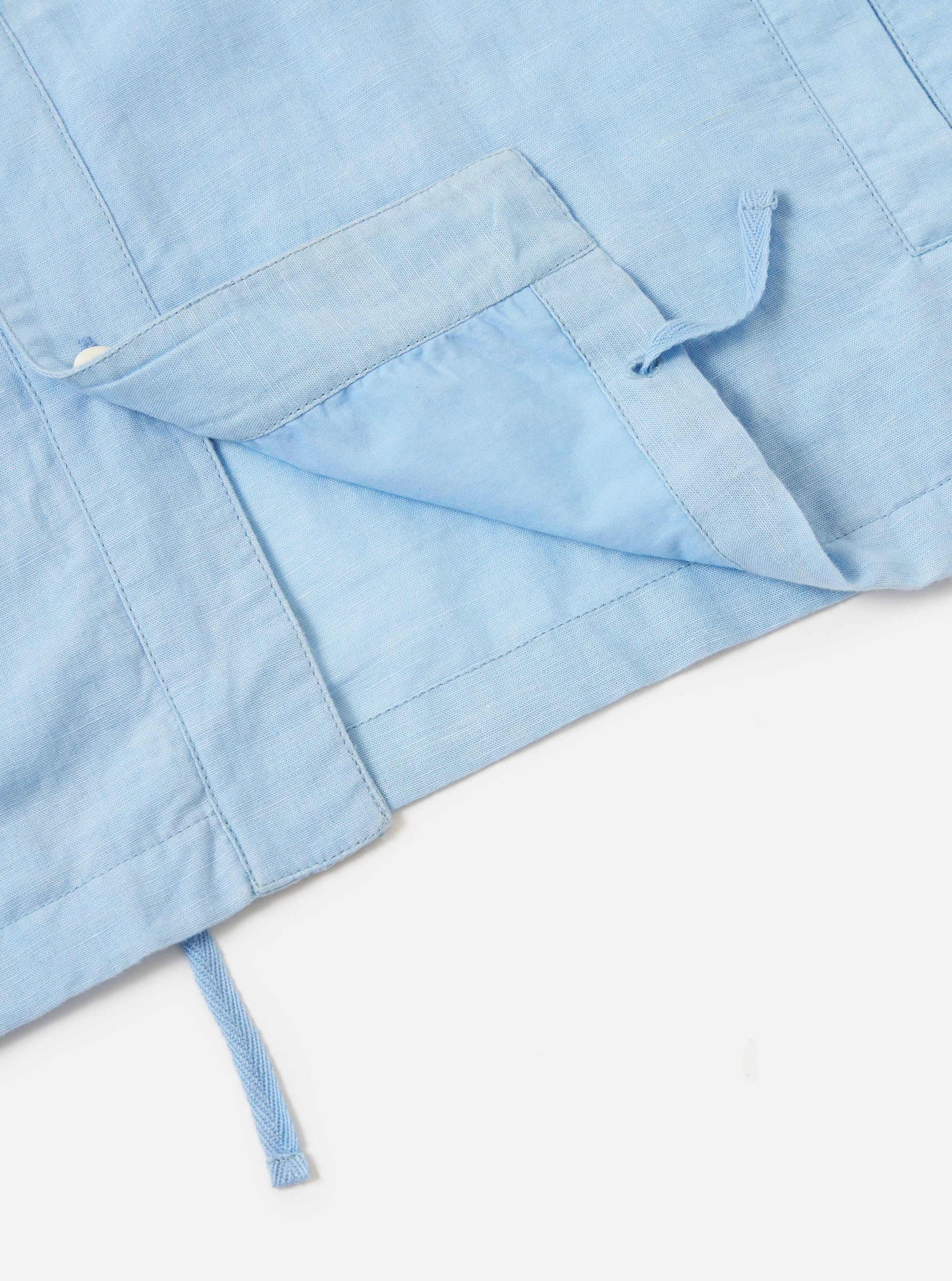 A Pale Blue Linen Cotton Shirting Parachute Shirt is displayed from a rear perspective against a plain white background. The image highlights the back yoke with two small pleats and the adjustable shirt cuffs.