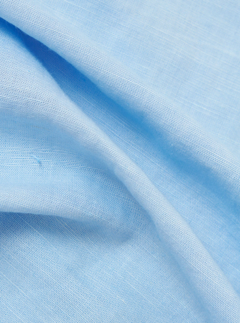 A close-up fabric swatch of the Pale Blue Linen Cotton Shirting Parachute Shirt. The image highlights the fine, textured weave of the material, which features a light blue color with a subtle, natural linen-cotton grain.