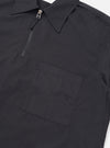 The back of the Black Broadcloth Ewan Shirt is shown laid flat against a plain white background. The image highlights the clean construction and smooth texture of the black cotton broadcloth fabric, featuring short sleeves and a straight hem.