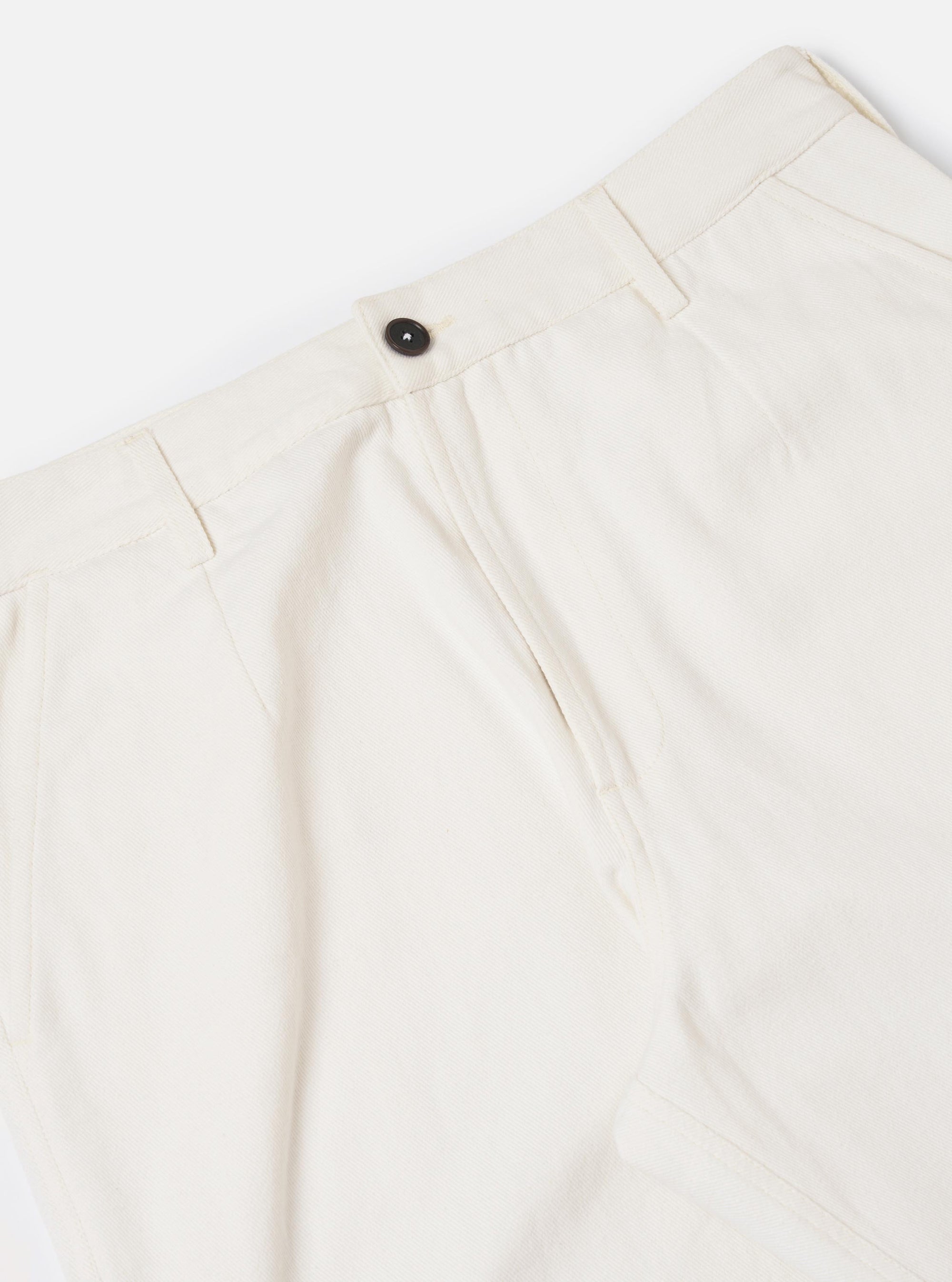 A pair of Ecru Slub Drill Dizzy Trousers is shown from a rear perspective, laid flat against a solid white background. The image highlights the two large rear patch pockets with buttoned flaps and the wide, slightly tapered cut of the off-white cotton fabric.