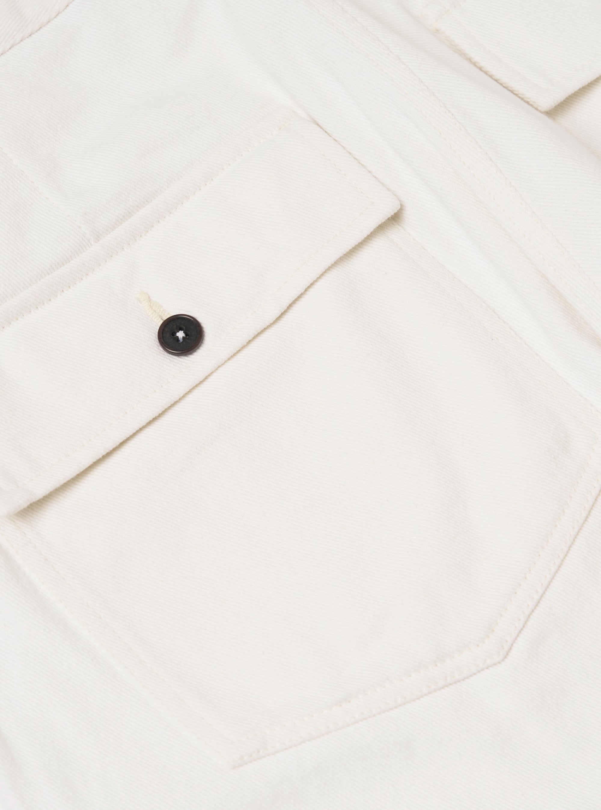 A close-up view of the back of a pair of Ecru Slub Drill Dizzy Trousers, focusing on the waistband and two rear buttoned flap patch pockets. The ecru-colored cotton fabric features a subtle slub texture and is displayed against a plain white background.