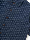 The Navy Chester Stripe S/S Fatigue Shirt is shown from the back, displayed flat against a plain white background. The image highlights the short sleeves, a straight hem, and a horizontal yoke across the shoulders of the navy and white striped fabric.