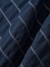A close-up fabric swatch of the Navy Chester Stripe S/S Fatigue Shirt shows a detailed view of the navy and blue chester stripe pattern. The image focuses on the texture and weave of the cotton fabric.