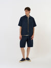 The Navy Paper Touch Cotton S/S Fatigue Shirt is shown laid flat against a solid white background. The short-sleeved overshirt features a classic pointed collar, a full button-down front, and two large patch pockets on the chest. The fabric is a crisp, navy blue cotton.