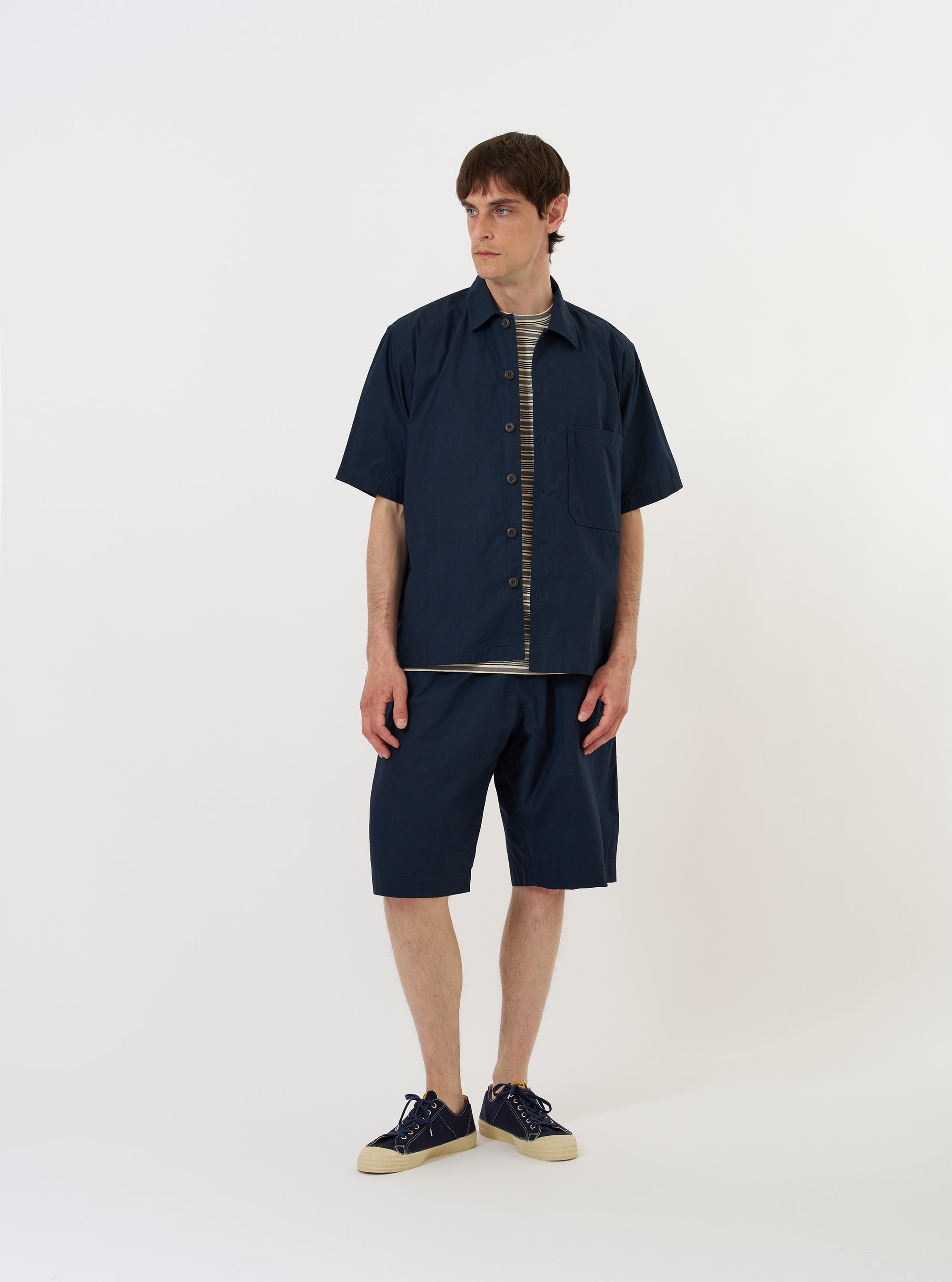 The Navy Paper Touch Cotton S/S Fatigue Shirt is shown laid flat against a solid white background. The short-sleeved overshirt features a classic pointed collar, a full button-down front, and two large patch pockets on the chest. The fabric is a crisp, navy blue cotton.