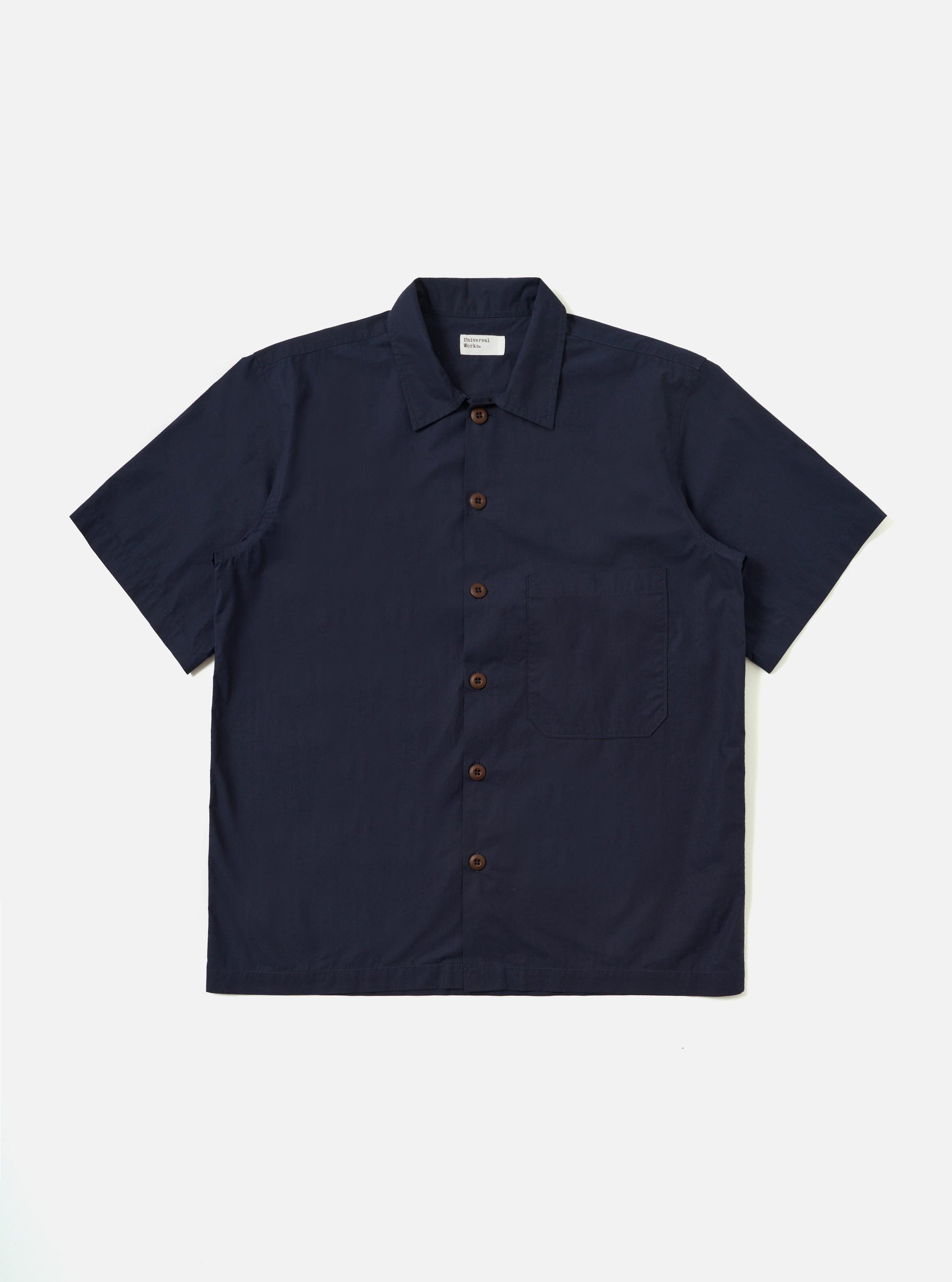 The Navy Paper Touch Cotton S/S Fatigue Shirt is shown laid flat against a solid white background. This short-sleeved overshirt features a dark navy color, a classic pointed collar, a full button-down front, and a single large patch pocket on the left chest. The garment has a straight hem and a loose, boxy fit.