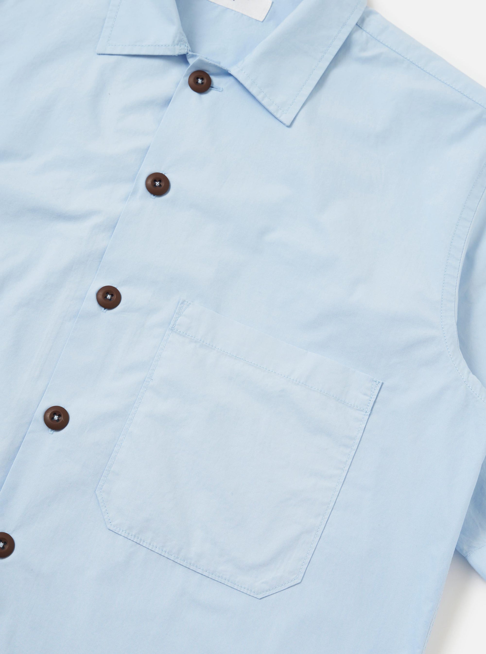 The Sky Blue Paper Touch Cotton S/S Fatigue Shirt is shown from the back, laid flat against a plain white background. The image highlights the short sleeves, a straight hem, and a classic pointed collar.